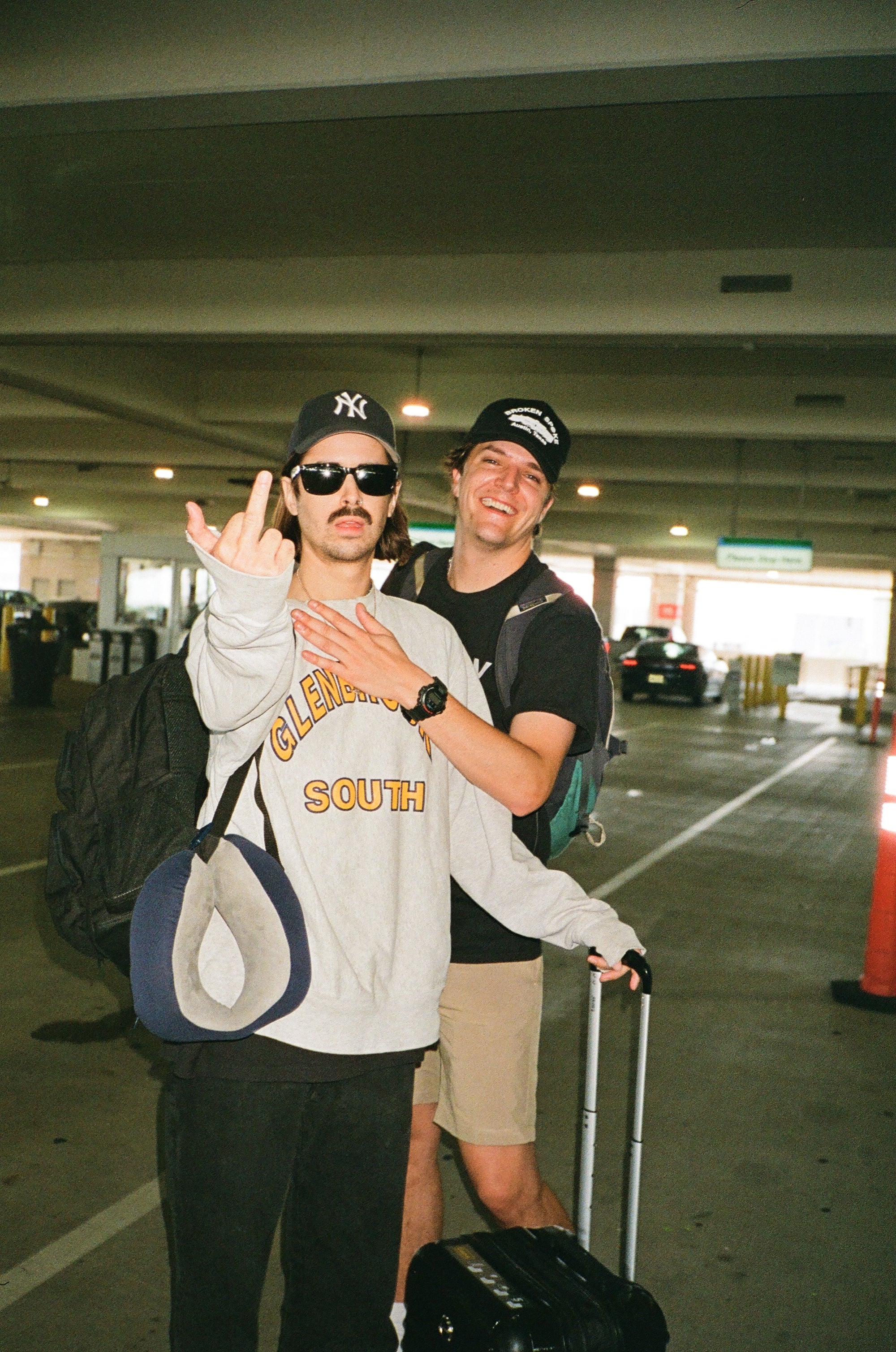 Two friends posing at an airport